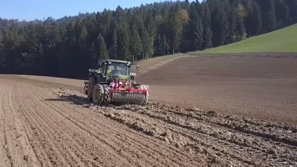 国外农场主驾驶约翰迪尔拖拉机牵引播种机作业