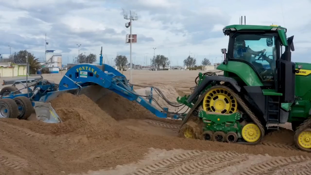 约翰迪尔和纽荷兰在海边沙滩进行平地作业